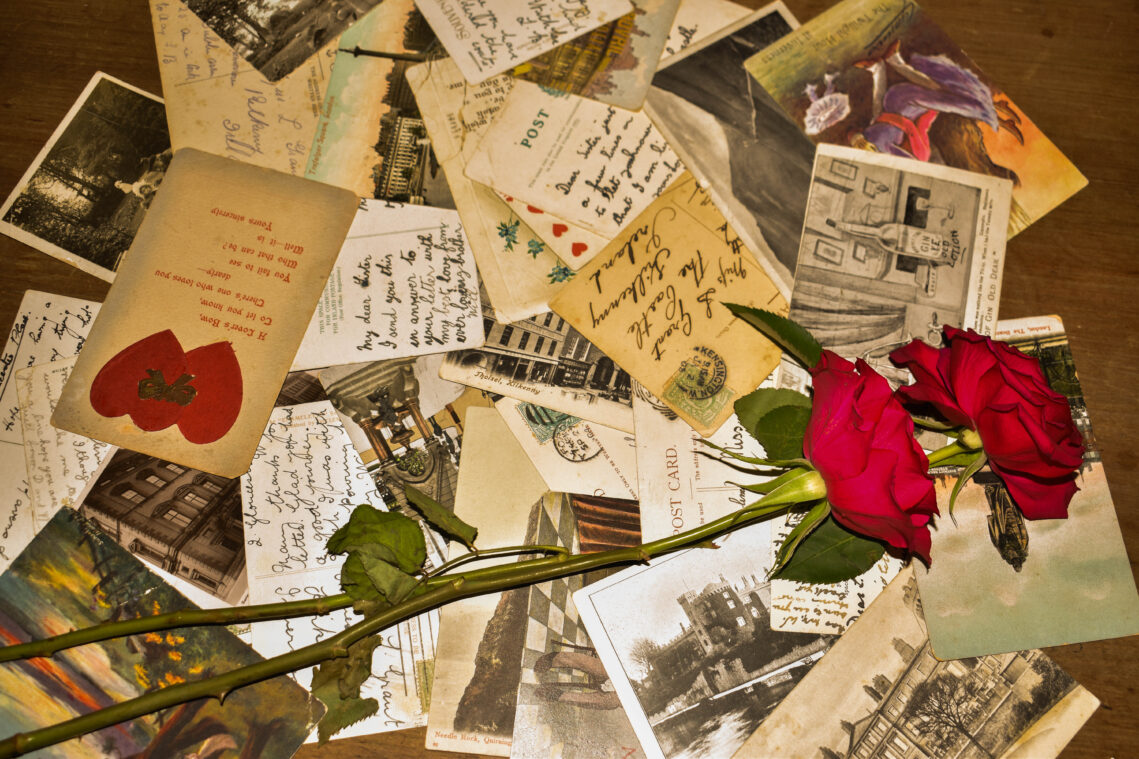 A collection of letters between lovers with a rose on top