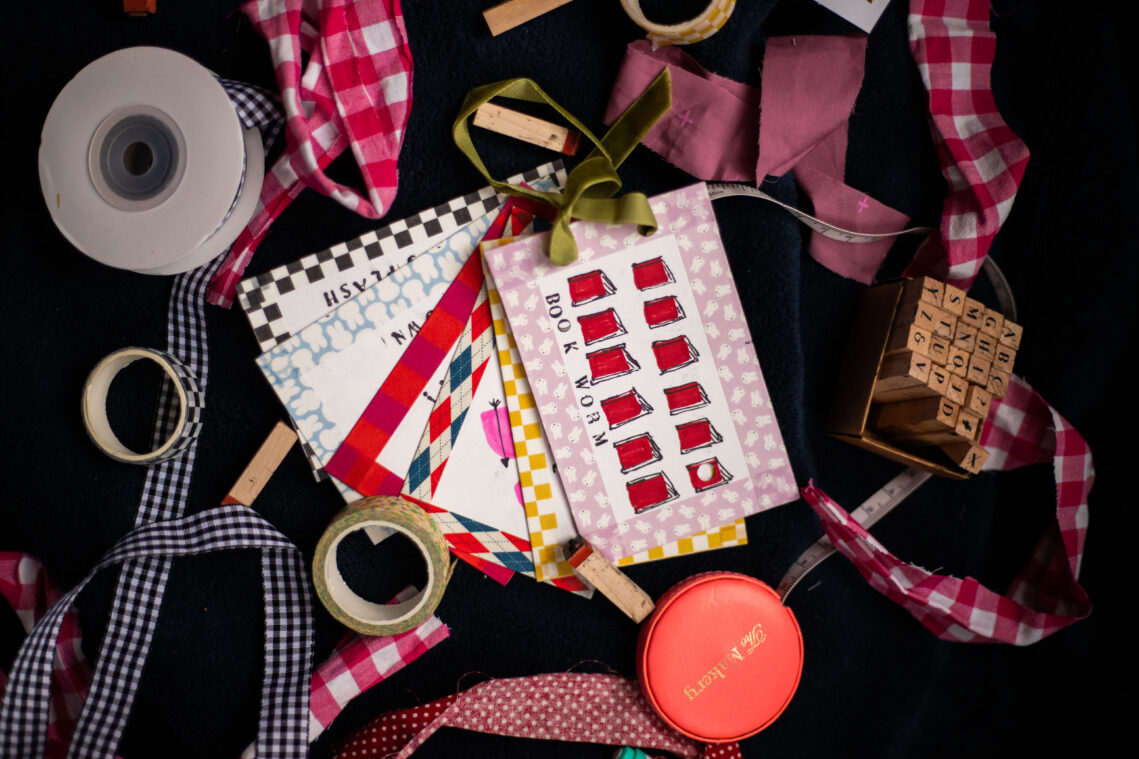 A number of cards, measuring tape and other handmade products laid out.
